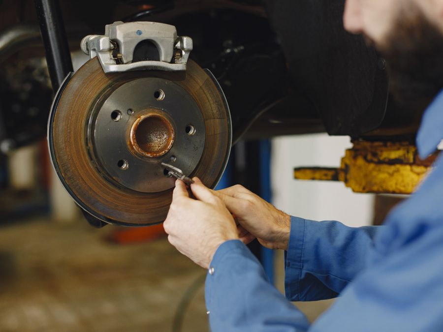 Mechanic servicing a car's brake rotor