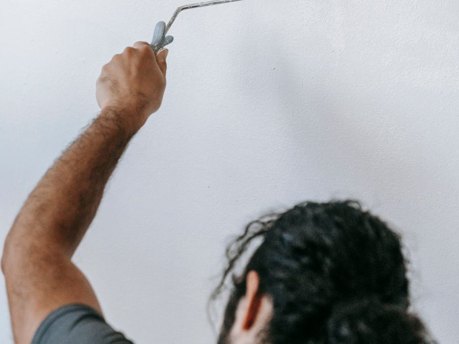 A painter rolling a smooth coat onto a wall